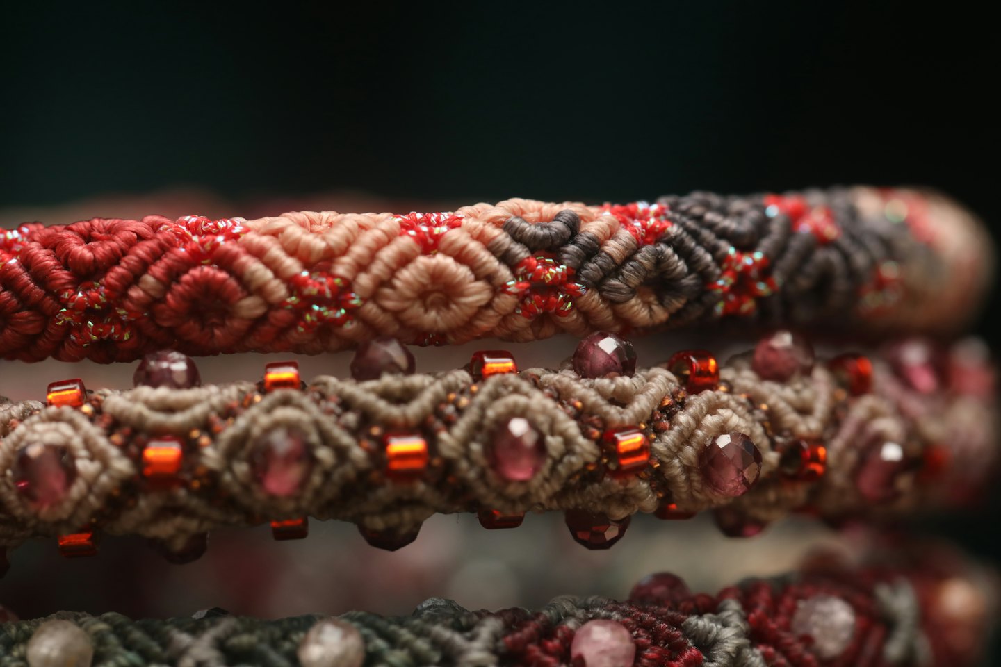 Braccialetti macramè intrecciati con perline, disposti in orizzontale.
